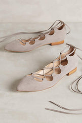 Suede shoes with pointed closed toes and low heels. Open on top like ballet flats but with criss-crossed laces that tie around the ankles.