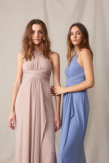 Image of two women in long dresses, one in blue and the other in pink, posing together.