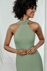 Gorgeous woman with curly dark hair smiling while rocking a green Amsale Sophia, halter top dress.