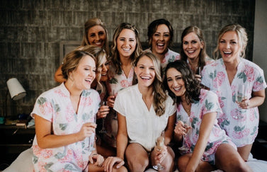 Bridesmaids in fun matching pj sets surround their bride in white pjs.