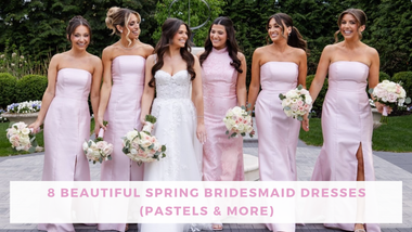 A smiling bride in a white gown stands with five bridesmaids in pastel pink dresses, holding bouquets in a garden—a cheerful spring wedding scene.