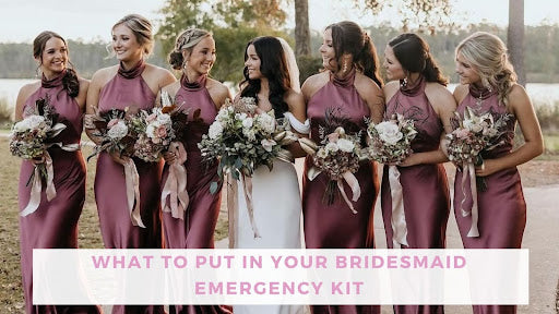 Bride in center of six bridesmaids. Bride wears white and smiles at the bridesmaid to her right, the bridesmaids are wearing shiny halter dresses.