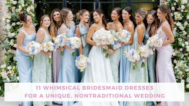 A bride and ten bridesmaids in pastel dresses pose with bouquets before a lush floral backdrop, smiling at a whimsical, nontraditional wedding.